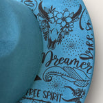 Load image into Gallery viewer, Blue suede hat with black tribal patterns and text on a white background
