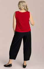 Load image into Gallery viewer, A woman shown from the back wearing a sleeveless red top and black cropped pants, standing against a plain light beige studio background.
