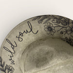 Load image into Gallery viewer, suede hat with 'wild soul' text and floral designs on a beige background
