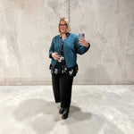 Load image into Gallery viewer, Person taking a mirror selfie wearing a blue jacket and black pants against a concrete wall.
