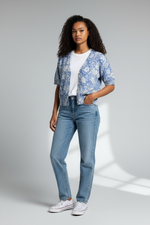Load image into Gallery viewer, Woman wearing a blue floral blouse, white t-shirt, and jeans on a gray background

