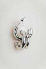 Load image into Gallery viewer, Silver hoop earrings on a light gray background
