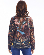 Load image into Gallery viewer, A woman viewed from the back wearing a long-sleeve top with a complex tropical and animal-print pattern in brown, black, blue, and pink, paired with blue jeans against a white background.
