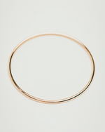 Load image into Gallery viewer, Gold hoop earring on a light gray background
