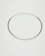 Load image into Gallery viewer, Silver hoop earring on a light gray background
