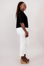 Load image into Gallery viewer, Woman wearing a black top and white pants on a plain background
