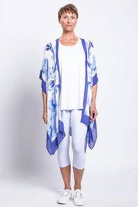 Woman wearing a blue and white patterned kimono-style garment over a white outfit on a white background
