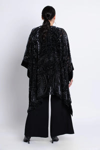 Woman wearing a black velvet patterned kimono on a white background