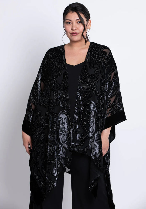 Woman wearing a black velvet patterned kimono on a white background