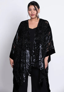 Woman wearing a black velvet patterned kimono on a white background