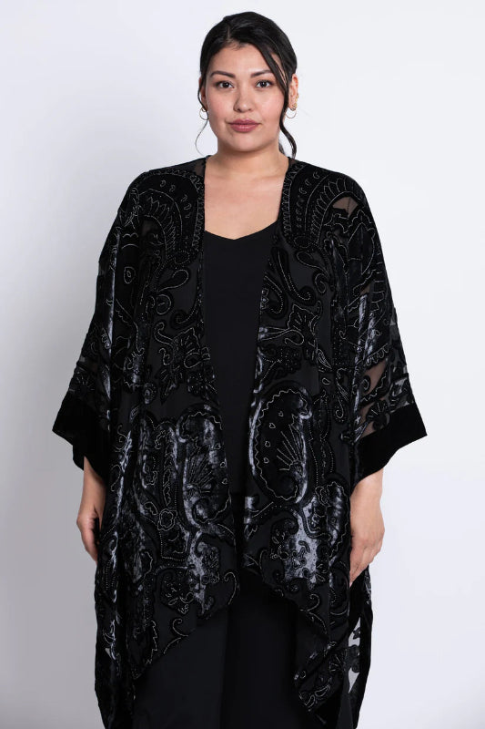 Woman wearing a black velvet patterned kimono on a white background
