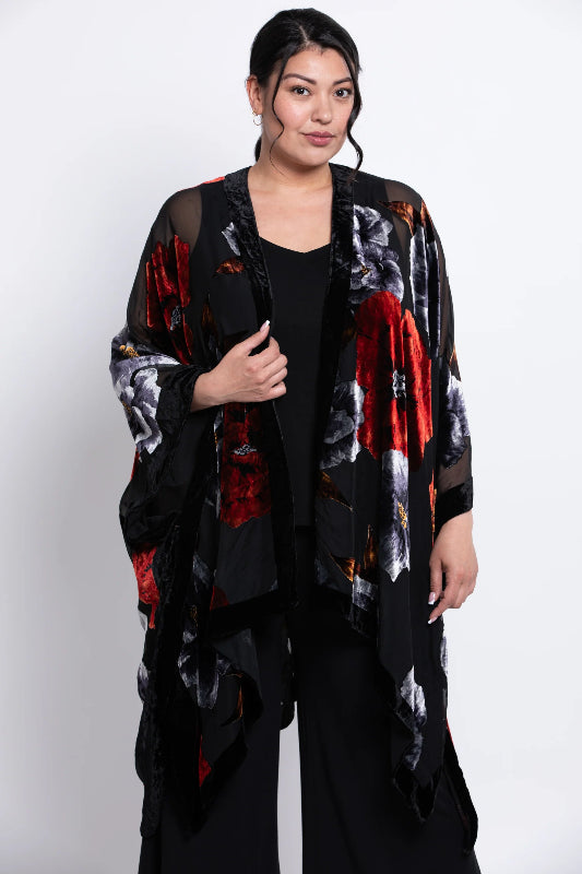 Woman wearing a black velvet
 kimono with red and white patterns on a white background