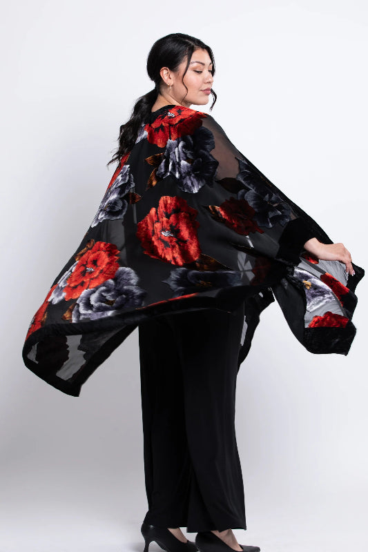Woman wearing a black velvet
 kimono with red and white patterns on a white background