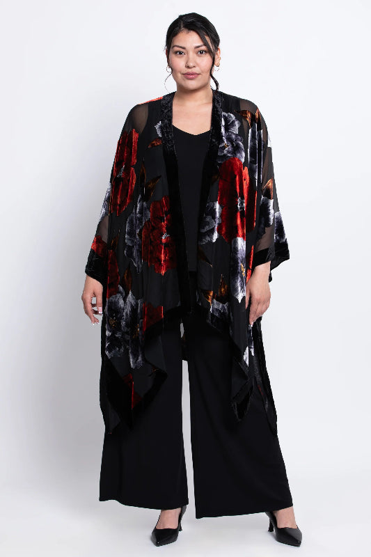 Woman wearing a black velvet
 kimono with red and white patterns on a white background