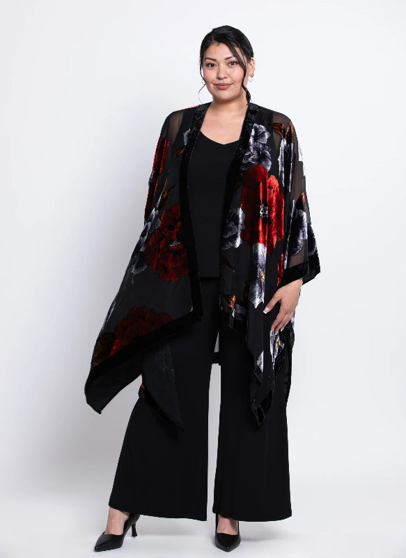 Woman wearing a black velvet
 kimono with red and white patterns on a white background