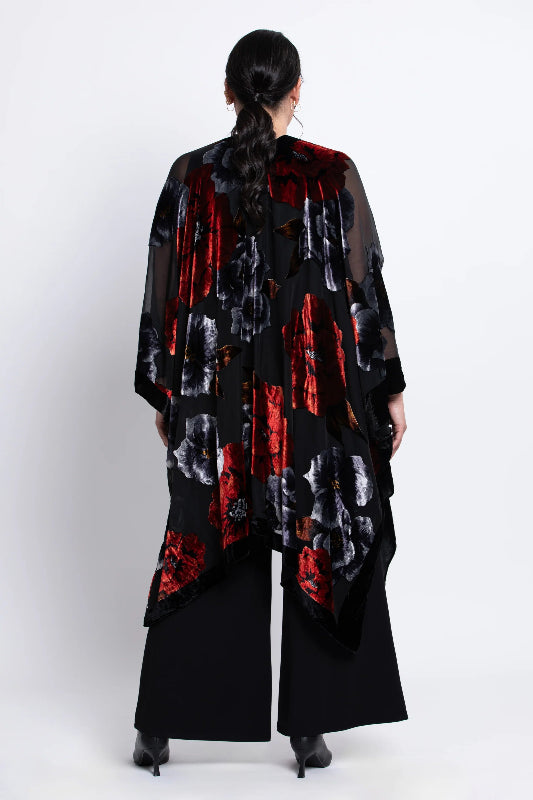 Woman wearing a black velvet
 kimono with red and white patterns on a white background