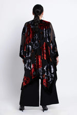 Load image into Gallery viewer, Woman wearing a black velvet
 kimono with red and white patterns on a white background
