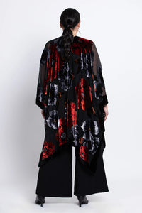 Woman wearing a black velvet
 kimono with red and white patterns on a white background