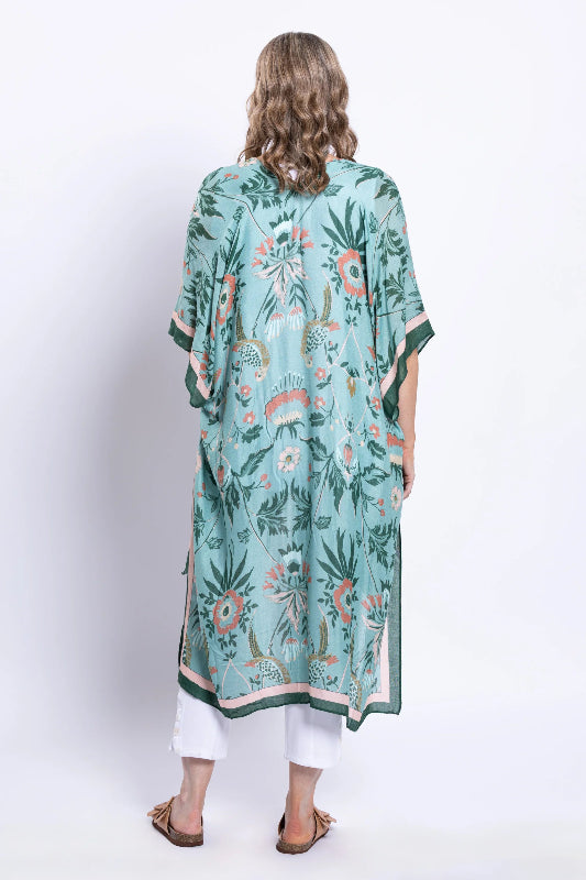 Woman wearing a green floral kimono-style garment on a white background