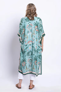 Woman wearing a green floral kimono-style garment on a white background