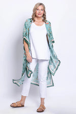 Load image into Gallery viewer, Woman wearing a green floral kimono over a white outfit on a white background
