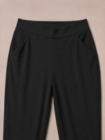 Load image into Gallery viewer, Black high-waisted cropped pants with side pockets, shown against a solid beige background.
