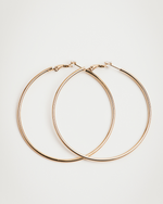 Load image into Gallery viewer, Gold hoop earrings on a light gray background
