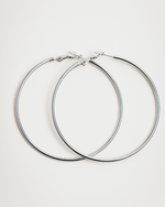 Load image into Gallery viewer, Pair of silver hoop earrings on a light gray background
