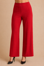 Load image into Gallery viewer, Red wide-leg cropped pants shown on a model from the waist down, paired with black pointed-toe heels against a solid beige studio background.
