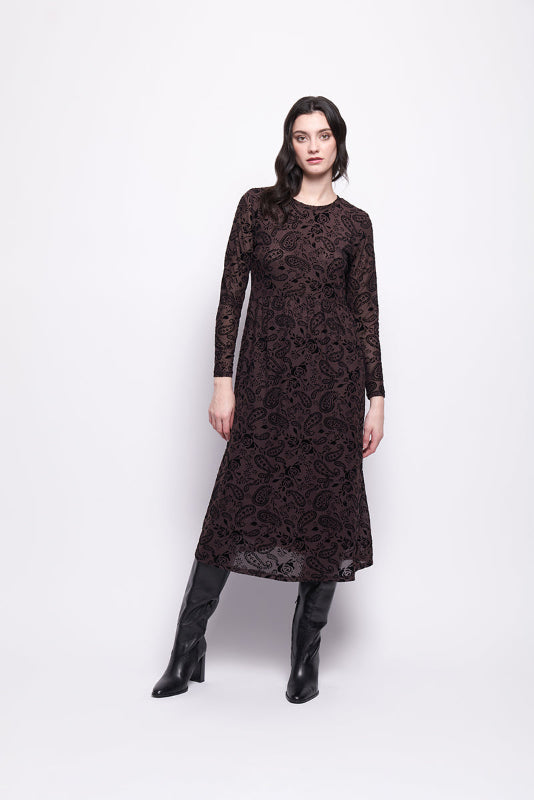 Woman wearing a brown mesh with black velvet dress and black boots on a white background