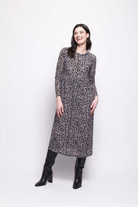 Woman wearing a grey mesh with velvet leopard print dress with black boots on a white background