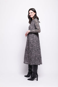Woman wearing a grey mesh with velvet leopard print dress with black boots on a white background