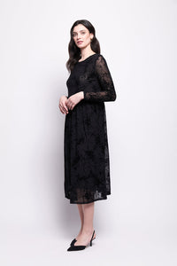 Woman wearing a black mesh with black velvet print dress on a white background