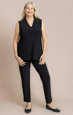 Load image into Gallery viewer, Woman wearing a black sleeveless top and pants on a beige background
