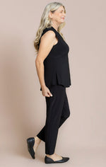 Load image into Gallery viewer, Woman wearing a black sleeveless top and pants against a beige background

