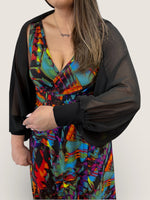 Load image into Gallery viewer, Person wearing a colorful dress with a black cardigan on a plain background

