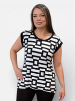 Load image into Gallery viewer, Woman wearing a black and white geometric patterned dress against a plain background

