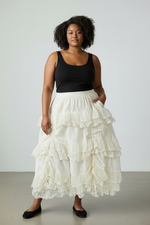 Load image into Gallery viewer, Woman wearing a black tank top and white ruffled skirt against a plain background
