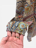 Load image into Gallery viewer, Close-up of a hand holding a folded paisley patterned fabric against a white background
