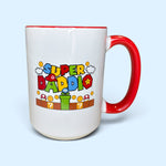 Load image into Gallery viewer, A white ceramic mug with a red handle and red interior rim, featuring a colorful 'Super Daddio' graphic inspired by Super Mario with Mario-style letters, coins, clouds, and a green pipe on the front, set against a light blue background.
