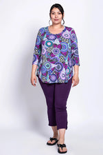 Load image into Gallery viewer, Woman wearing a patterned top and purple pants on a white background
