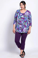 Load image into Gallery viewer, Woman wearing a colorful patterned top and purple pants on a white background
