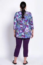 Load image into Gallery viewer, Woman wearing a colorful patterned top and purple pants on a white background
