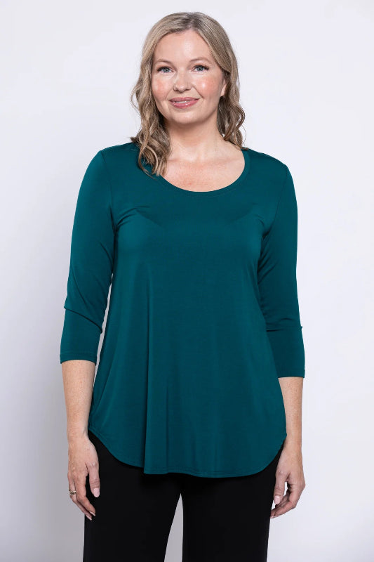 Woman wearing a teal top against a white background