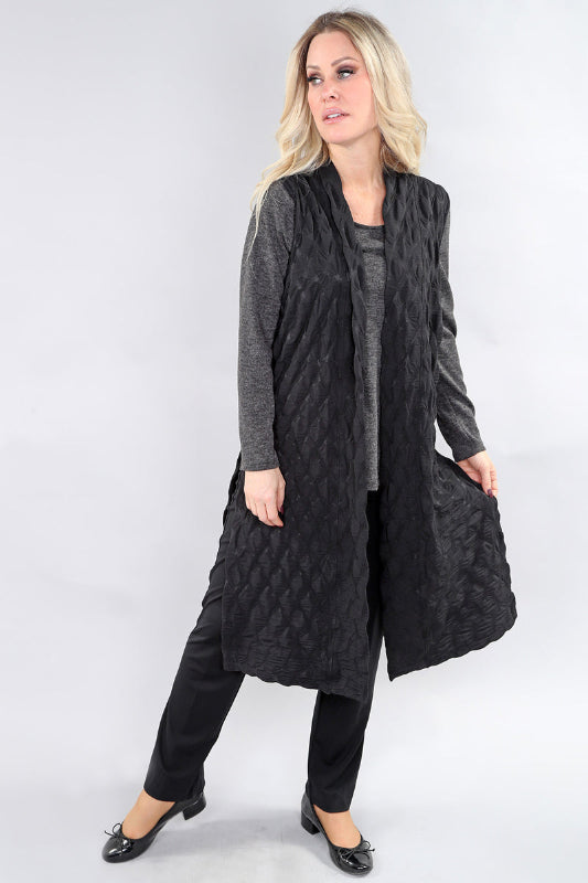 Woman wearing a long black quilted look Vest on a white background