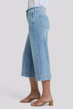 Load image into Gallery viewer, Light blue jeans worn by a person on a white background
