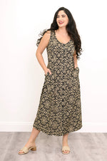 Load image into Gallery viewer, Woman wearing a floral patterned dress on a plain background
