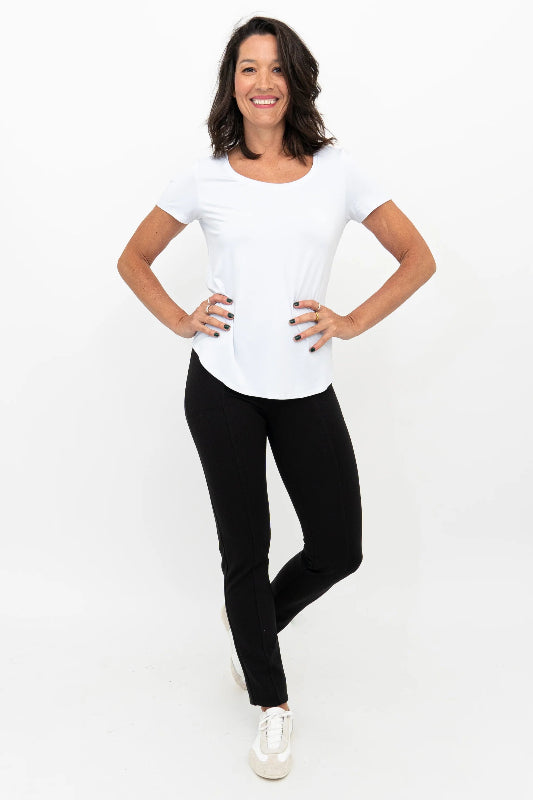 Woman wearing a white top and black pants on a white background