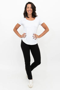Woman wearing a white top and black pants on a white background
