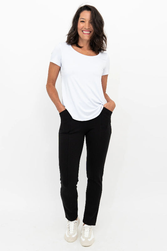 Woman wearing a white t-shirt and black pants on a white background